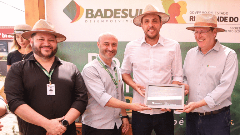 Quatro homens sorrindo em uma entrega de premiação